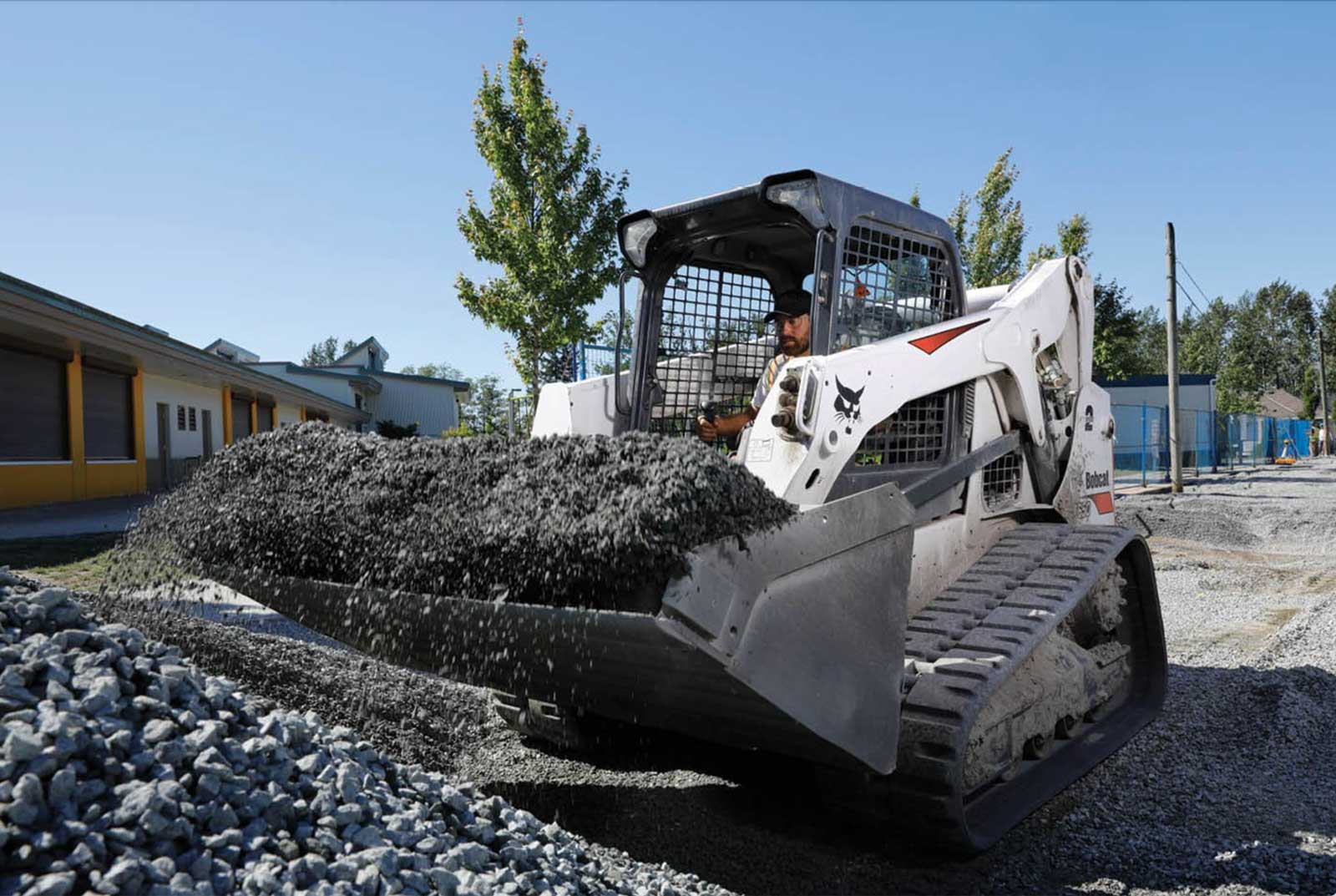 Skid steer picking up a load of gravel.